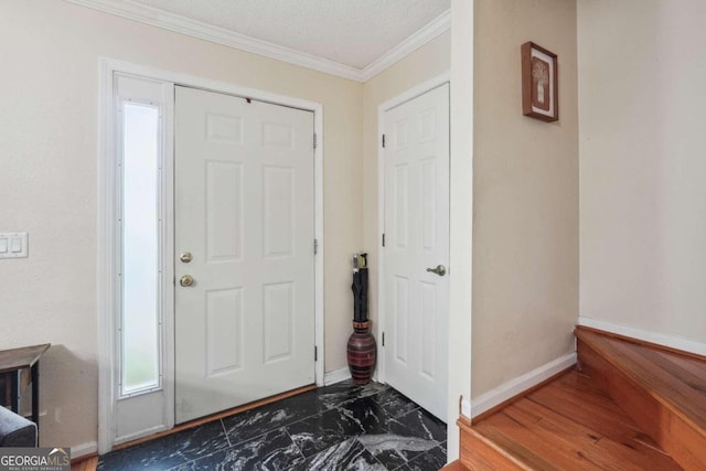 foyer entrance with a textured ceiling, crown molding, and dark hardwood / wood-style flooring