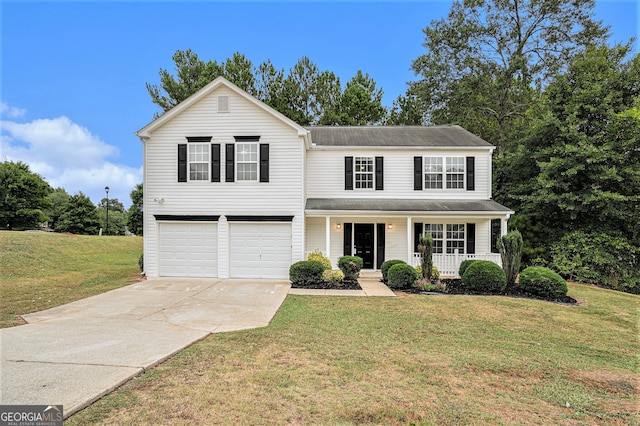 view of property with a garage, covered porch, and a front yard