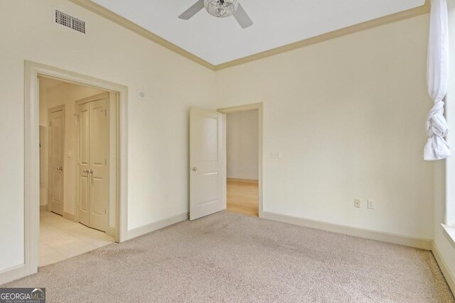 carpeted empty room with ceiling fan, a healthy amount of sunlight, and crown molding