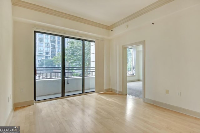 empty room with light hardwood / wood-style flooring, ornamental molding, and plenty of natural light