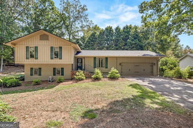 tri-level home featuring a garage and a front lawn