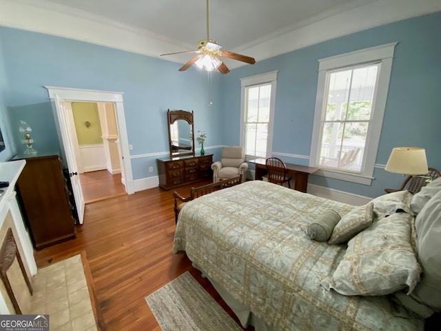 bedroom featuring wood-type flooring, ceiling fan, and crown molding