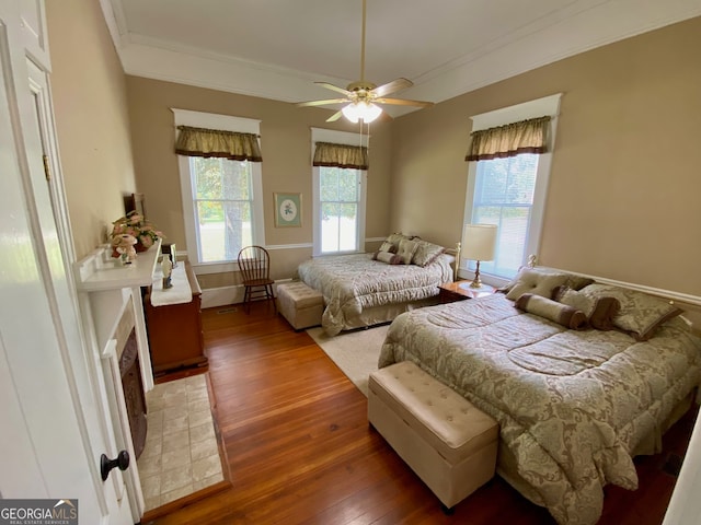 bedroom featuring multiple windows, ornamental molding, hardwood / wood-style floors, and ceiling fan