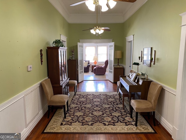 interior space with ceiling fan, ornamental molding, and dark wood-type flooring