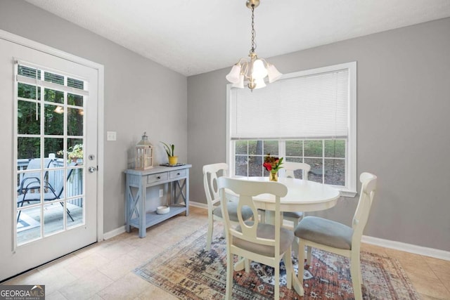 dining room featuring light tile patterned floors, a healthy amount of sunlight, and an inviting chandelier