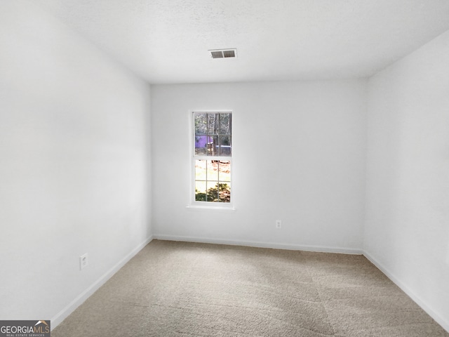 carpeted empty room with a textured ceiling