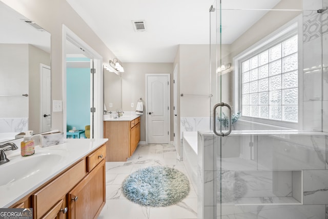 bathroom with vanity and shower with separate bathtub