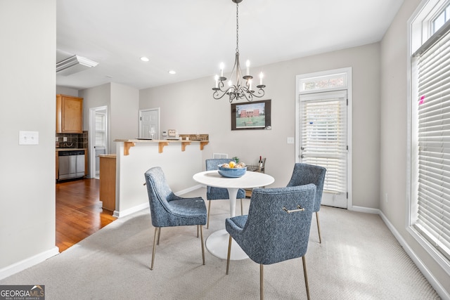 dining space with an inviting chandelier and light hardwood / wood-style flooring