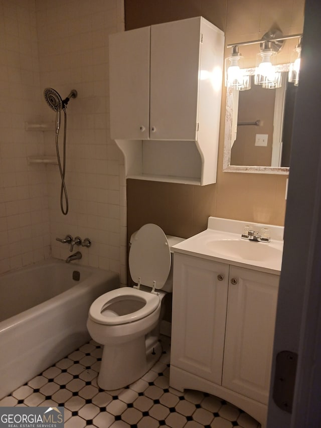 full bathroom with vanity, tiled shower / bath combo, and toilet