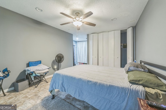 bedroom with a textured ceiling and ceiling fan