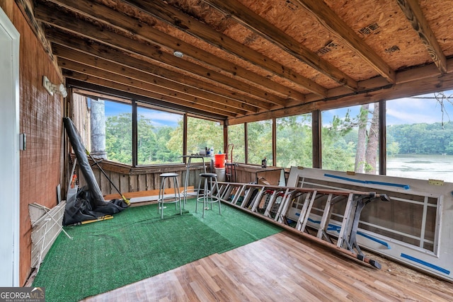 sunroom with a water view and vaulted ceiling