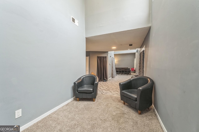 living area with light carpet and a high ceiling