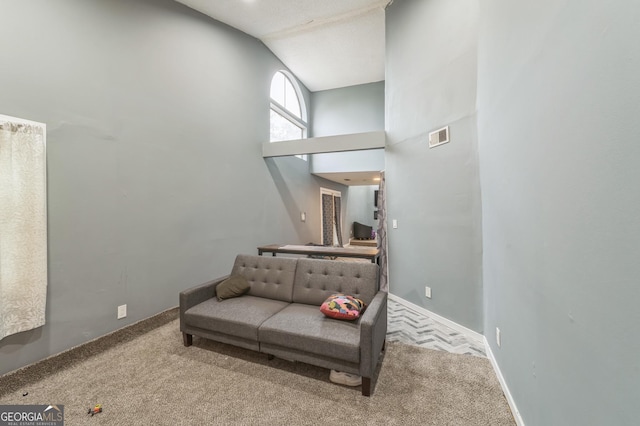 sitting room featuring vaulted ceiling and carpet flooring