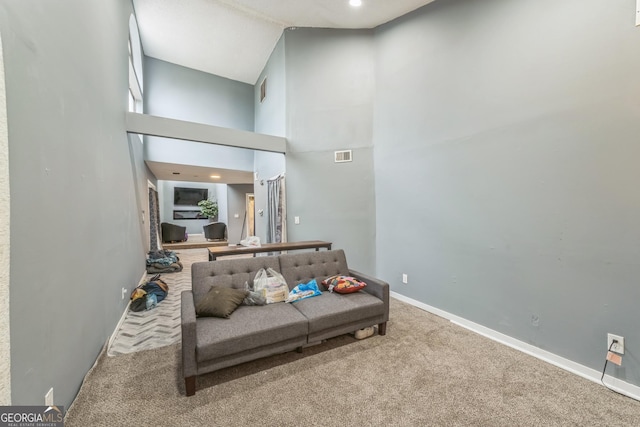 carpeted living room with a towering ceiling