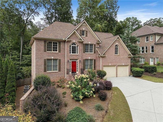 view of front of property with a garage and central AC