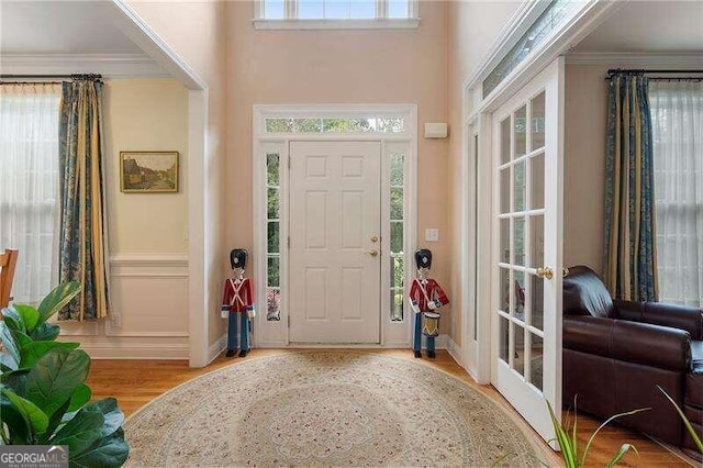 foyer entrance featuring crown molding, light hardwood / wood-style floors, and plenty of natural light