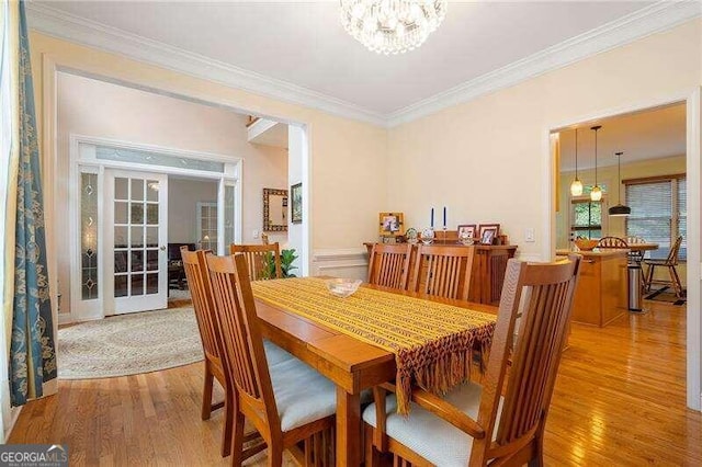 dining area featuring ornamental molding, a notable chandelier, and hardwood / wood-style floors