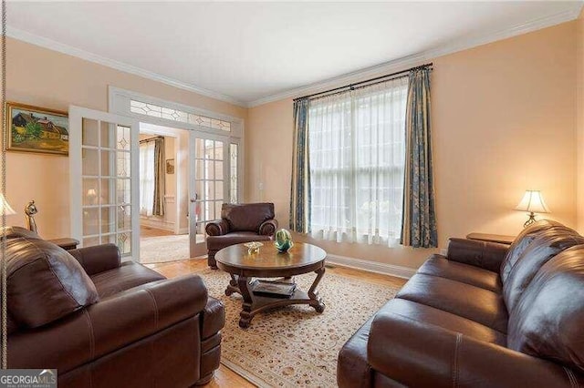 living room with light wood-type flooring, a healthy amount of sunlight, ornamental molding, and french doors