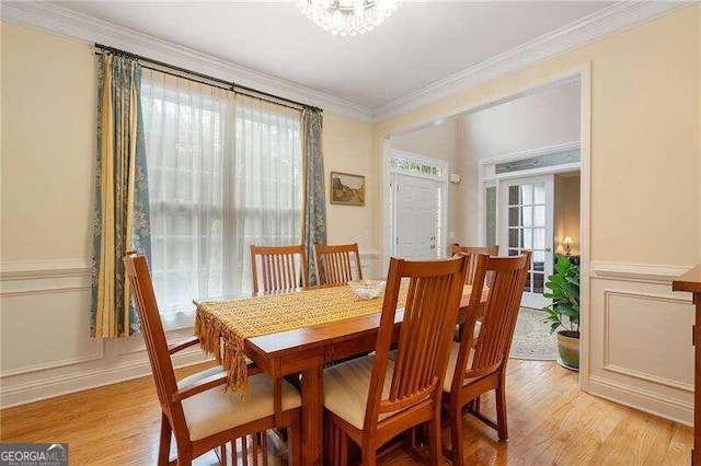 dining room featuring light hardwood / wood-style floors, ornamental molding, and a wealth of natural light