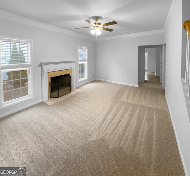 unfurnished living room with ceiling fan, ornamental molding, a high end fireplace, and a healthy amount of sunlight