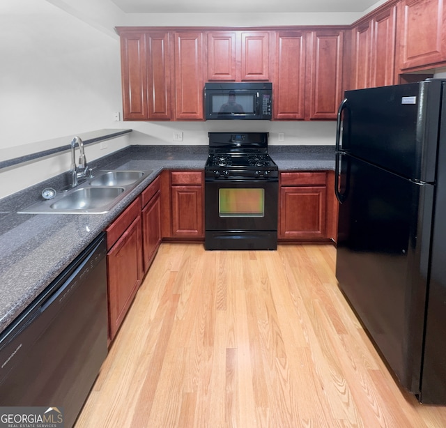 kitchen featuring sink, light hardwood / wood-style floors, and black appliances