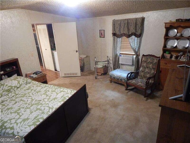 carpeted bedroom with cooling unit, vaulted ceiling, and a textured ceiling