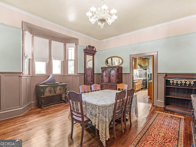 dining area featuring light hardwood / wood-style flooring, a chandelier, and crown molding