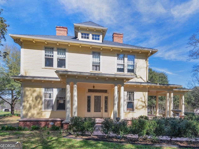 rear view of property featuring covered porch