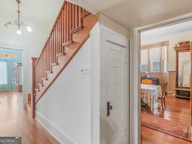 stairway featuring an inviting chandelier and hardwood / wood-style flooring