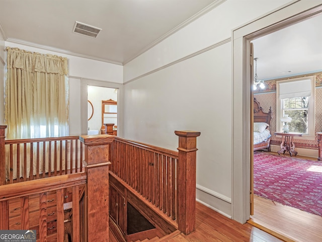 hall with ornamental molding and wood-type flooring