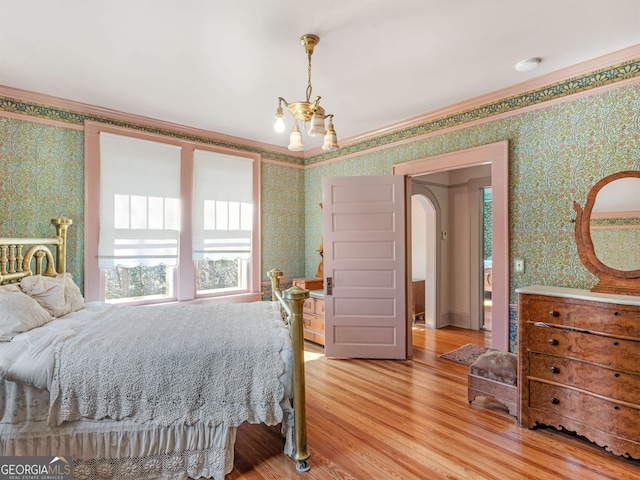 bedroom featuring a chandelier, light hardwood / wood-style floors, and crown molding