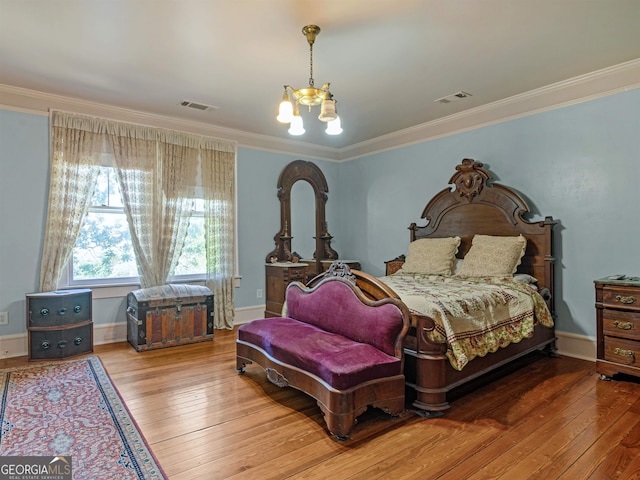 bedroom featuring hardwood / wood-style flooring, crown molding, and a chandelier