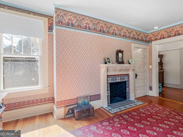 living room featuring ornamental molding, a tile fireplace, and hardwood / wood-style floors