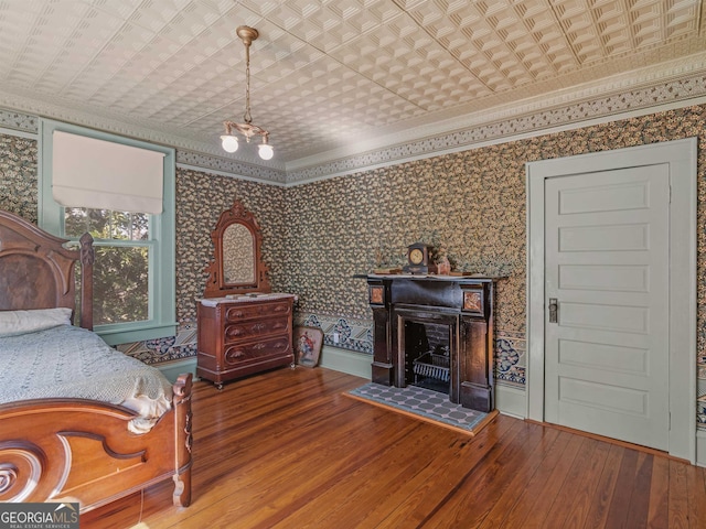 bedroom featuring hardwood / wood-style floors and crown molding