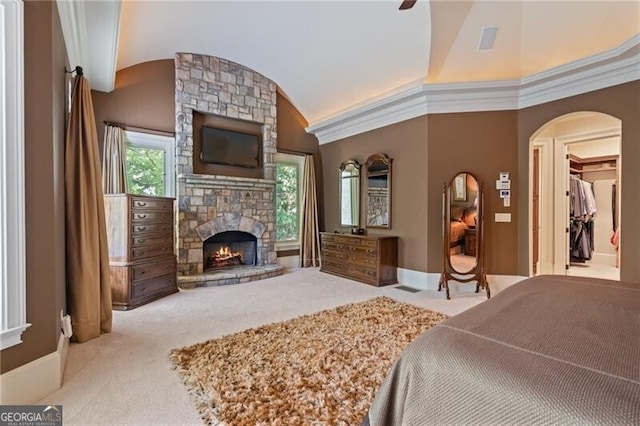 bedroom featuring ceiling fan, high vaulted ceiling, light colored carpet, a fireplace, and crown molding