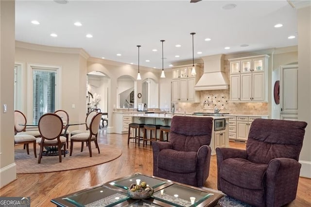 living room featuring crown molding and light hardwood / wood-style flooring