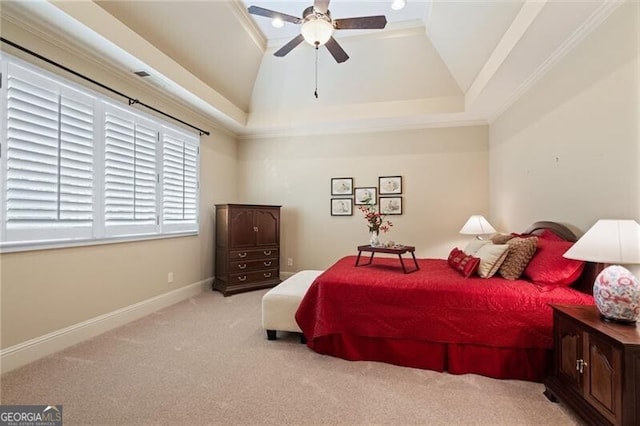 carpeted bedroom with ceiling fan, a tray ceiling, ornamental molding, and lofted ceiling