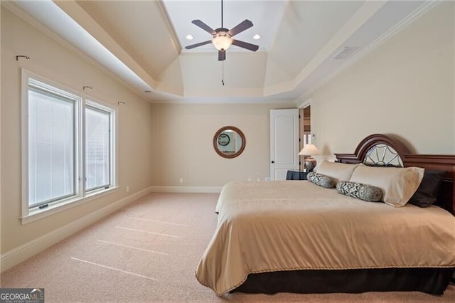 bedroom featuring ceiling fan, a raised ceiling, light carpet, and ornamental molding