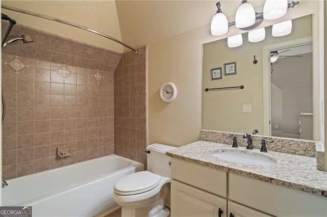 full bathroom featuring ceiling fan, tiled shower / bath, vanity, and toilet