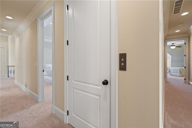 hall featuring ornamental molding and light colored carpet