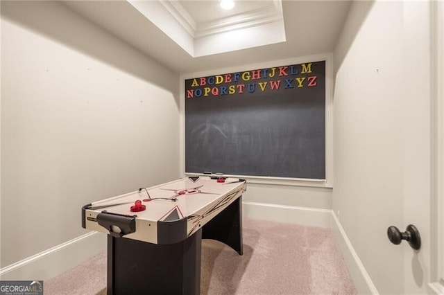 playroom featuring light carpet, a raised ceiling, and crown molding