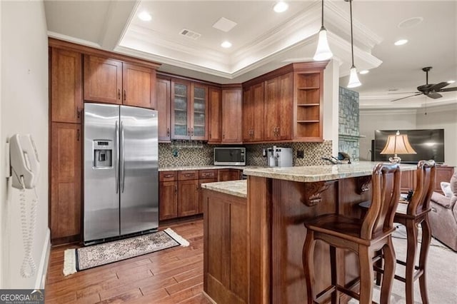 kitchen with appliances with stainless steel finishes, kitchen peninsula, dark hardwood / wood-style flooring, ceiling fan, and ornamental molding