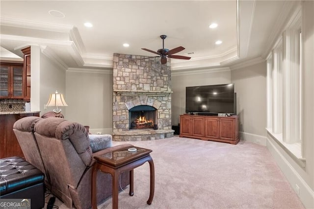 carpeted living room featuring ceiling fan, a raised ceiling, a fireplace, and crown molding