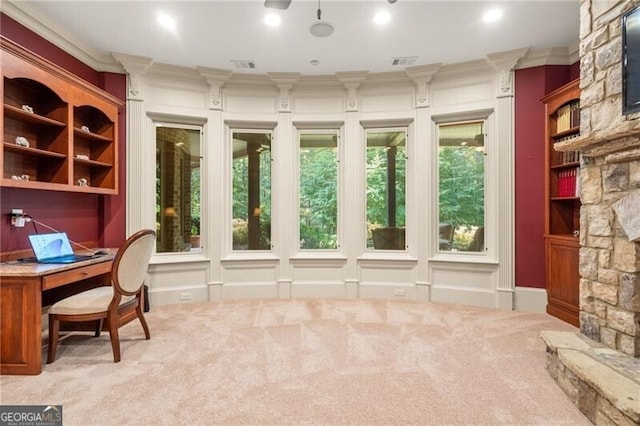 carpeted home office with crown molding, a fireplace, and plenty of natural light