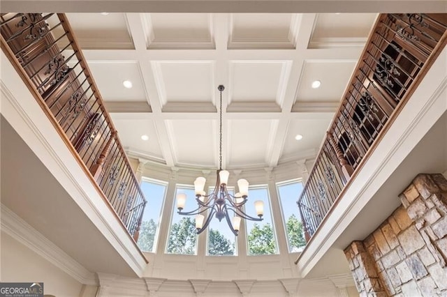 room details featuring crown molding, coffered ceiling, beamed ceiling, and a notable chandelier