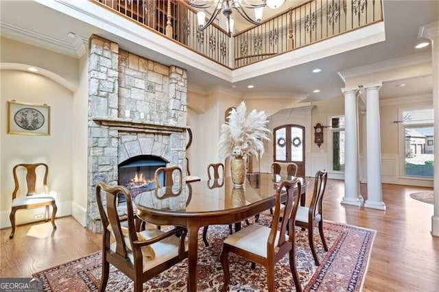 dining room with an inviting chandelier, crown molding, a towering ceiling, and hardwood / wood-style floors