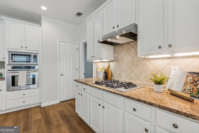 kitchen featuring white cabinets, appliances with stainless steel finishes, dark hardwood / wood-style floors, and tasteful backsplash