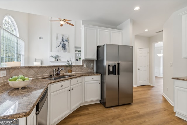 kitchen featuring ceiling fan, light hardwood / wood-style flooring, backsplash, white cabinetry, and stainless steel appliances