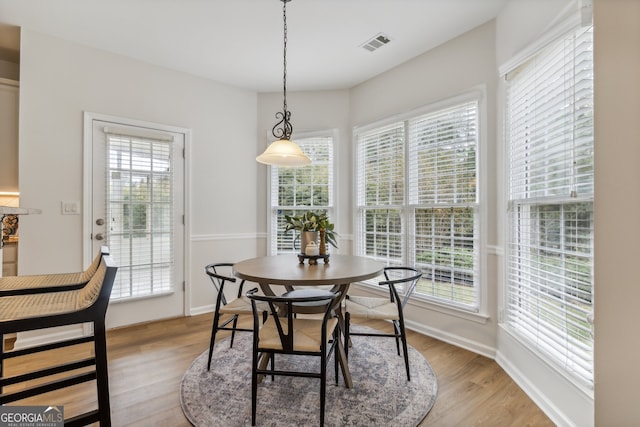 dining room with light hardwood / wood-style flooring and a healthy amount of sunlight