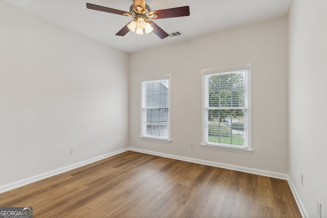 empty room with ceiling fan and hardwood / wood-style flooring